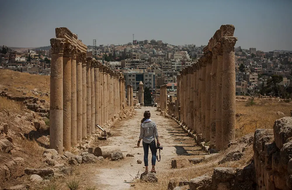 G Adventures gees up for 2025 GX Jordan Summit with 7 impactful changemakers headlining 2 Jordan Jerash Pillars Ruins Traveller with Camera. Image: G Adventures