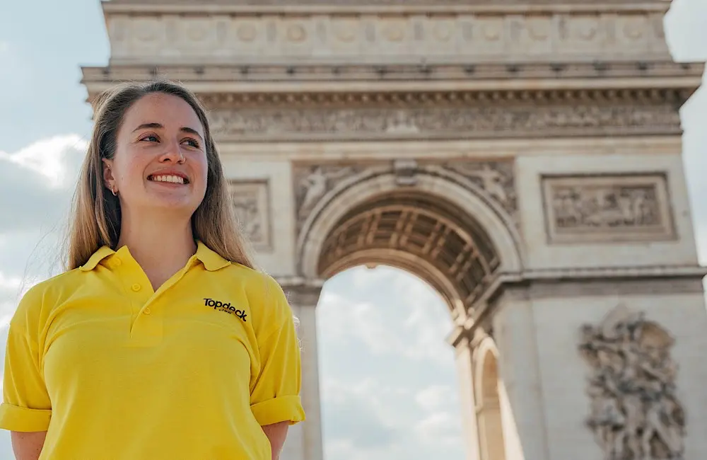 Smaller groups, bigger value: Topdeck’s new small-group travel style is packed with more for your Gen Z clients 6 Topdeck Trip Leader in branded yellow t-shirt in front of the Arc de Triomphe in Paris.