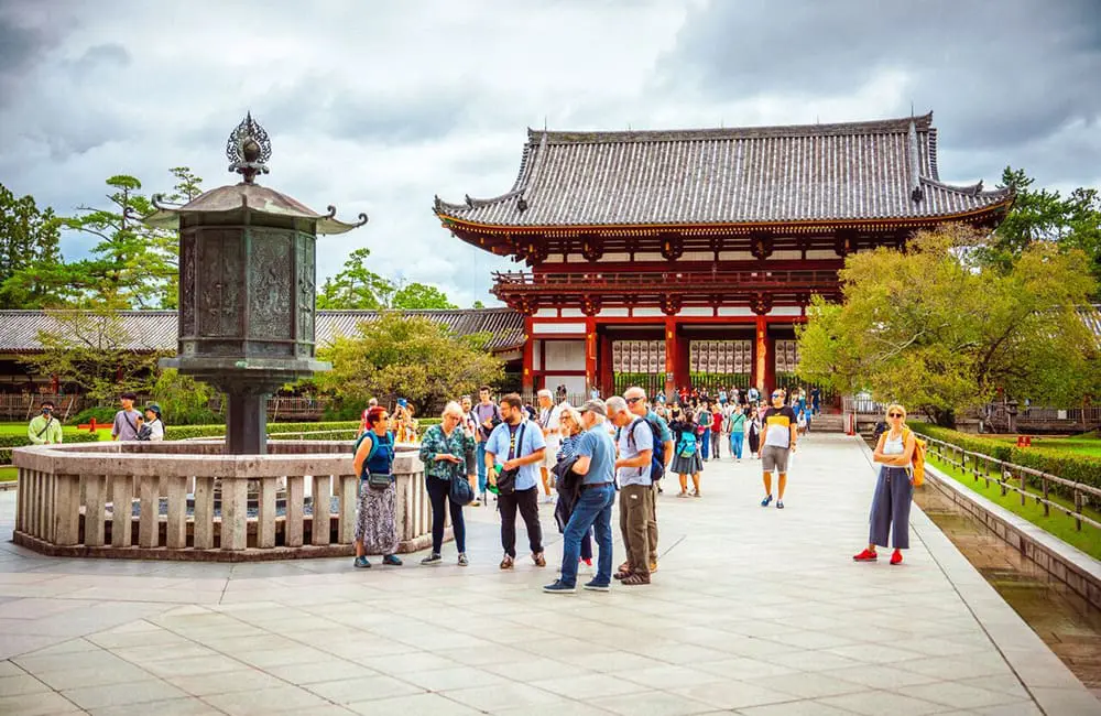 InsideJapan launches largest-ever small-group tour program for 2026 as interest hits record highs 3 InsideJapan tour leader and group in Nara in front of temple.