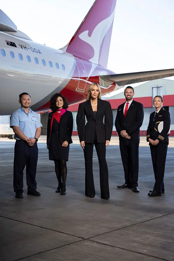 Qantas announces Aussie female designer to fashion the first new crew look in over a decade 3 Rebecca Vallance (middle) with QF crew in the current uniform.