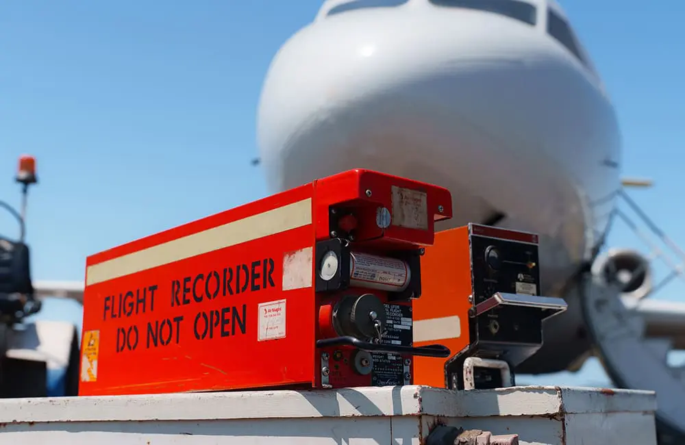 Bid & fly: Brisbane Airport’s biggest-ever lost property auction takes off for 2025 5 Black box cockpit recorder with aircraft on tarmac in background – Brisbane Airport Lost Property Auction 2025