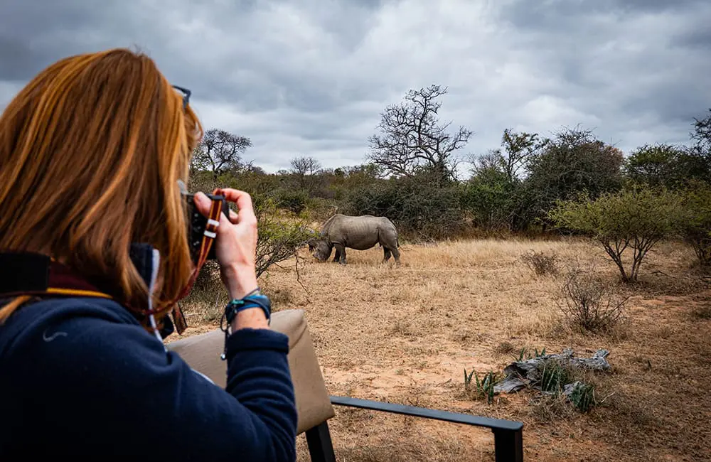 Explore Worldwide reveals the key travel shifts shaping how & why we’ll travel in 2026 1 Woman taking a photo of a rhino from a safari vehicle – Explore Worldwide Travel Trends Report 2026