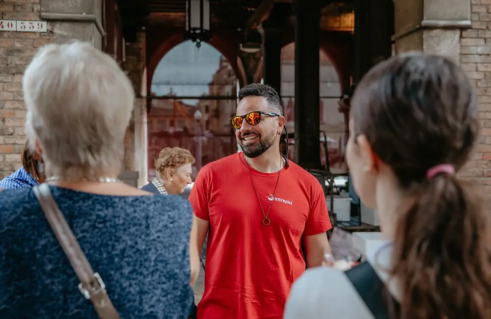 Intrepid’s new Short Breaks turn 27 days off into 59 days of adventure in 2026 1 Intrepid Travel trip leader with Short Breaks tour group in Venice, Italy.