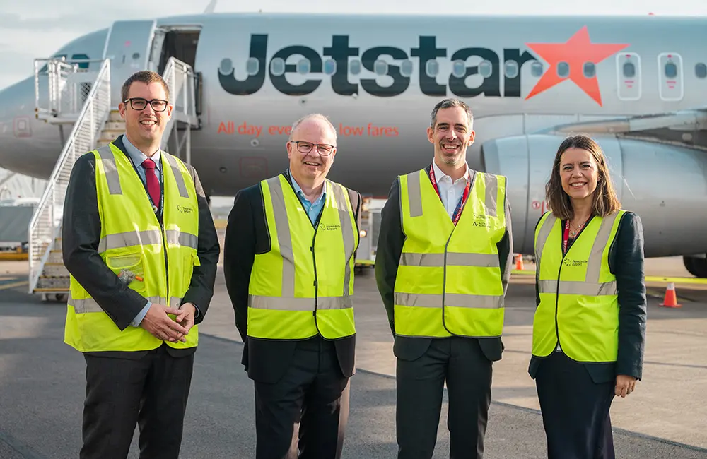 Newcastle goes international again with first-ever Jetstar Bali flight; drops 24-hour sale 1 Newcastle Airport executive team on tarmac in front of Jetstar aircraft