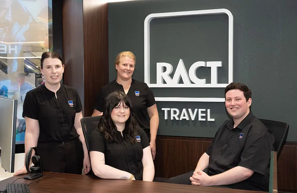 RACT Travel Rosny turns heads with Tasmania’s first-ever LED glass shopfront 3 RACT Travel Rosny team at agent desk.
