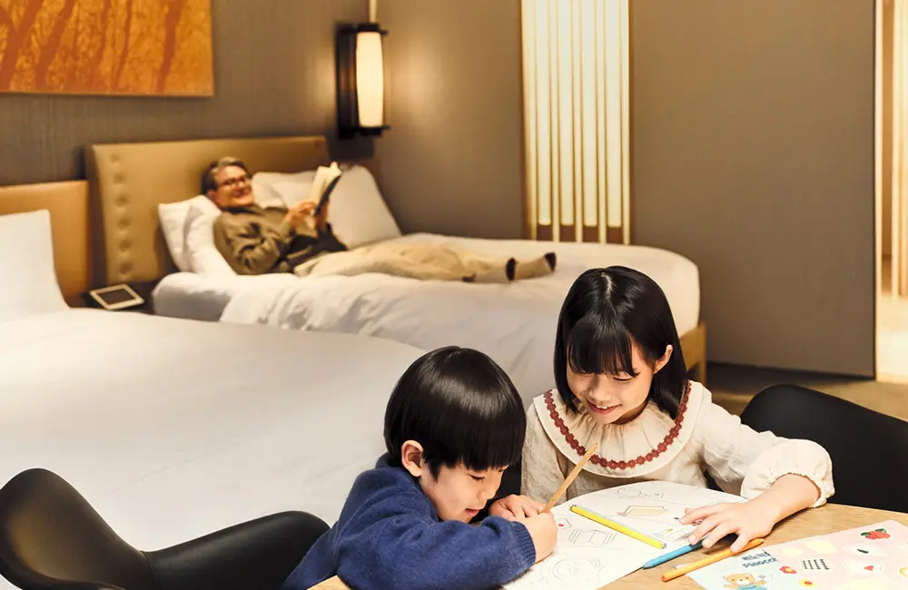 What's skip-gen travel – and why is it taking off in Australia right now? 1 Grandad and grandkids in Conrad Seoul hotel room for skip-gen travel concept.