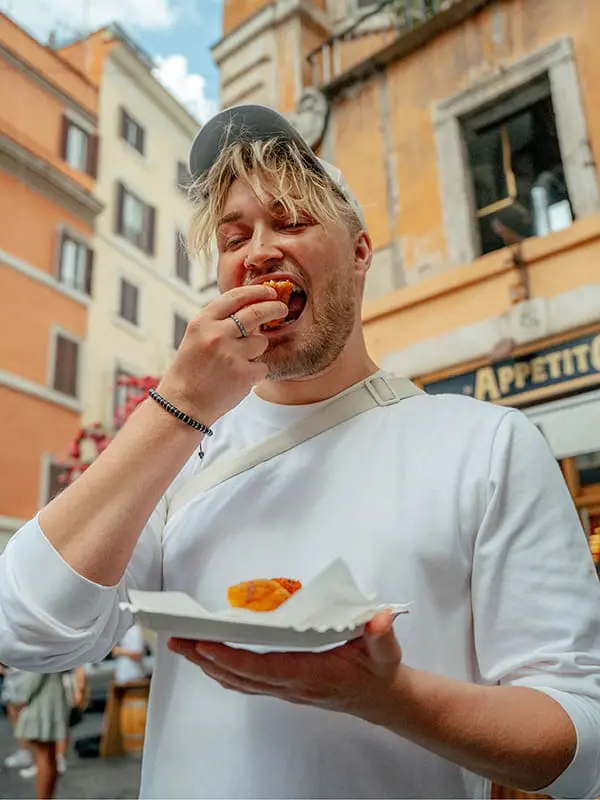 Smaller groups, bigger value: Topdeck’s new small-group travel style is packed with more for your Gen Z clients 4 Topdeck traveller eating street food in Italy.