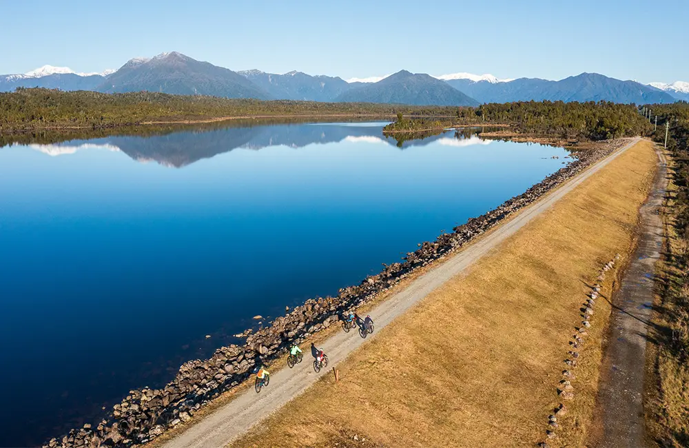 Australians ride the wave of regenerative tourism on New Zealand's Great Rides 2 Riders-on-West-Coast-Wilderness-Trail-Kapitea-Reservoir-south-of-Kumara