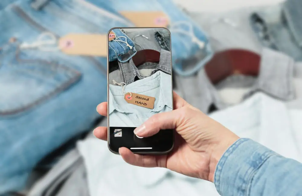 Taking photo on phone of secondhand denim – going broke for a break