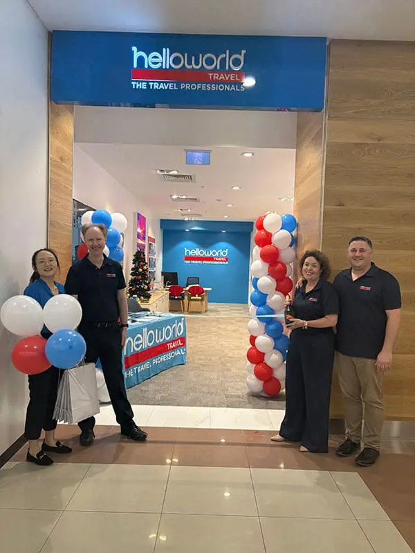 Helloworld Travel owner becomes multi-store operator with new Queensland opening 2 Helloworld Travel Mt Gravatt consultant Joanna Zhou and store owner Colin Jakins cut the ribbon with Qld Business Manager Christine Dilger and GM Network Development Adrian Boccia.