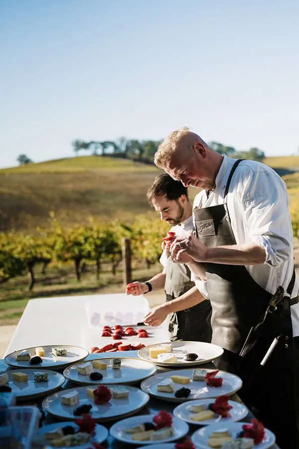 Chefs plating cheese plates outdoors in South Australia's Fleurieu Peninsula. Image: Tasting Australia
