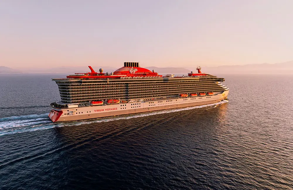 Virgin Voyages just launched a game-changing Status Match offer – are you eligible? 4 Virgin Voyages cruise ship at sea during sunset.