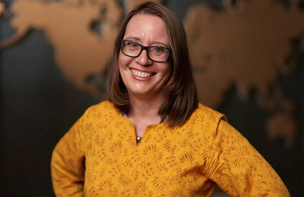 Intrepid Travel GM Climate Dr Susanne Etti against map background