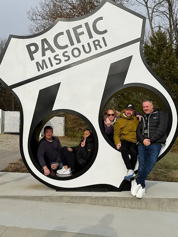 Tour group hanging out in one of the commemorative Route 66 Centennial signs in Pacific, MO. Image: Cassie Tannenberg