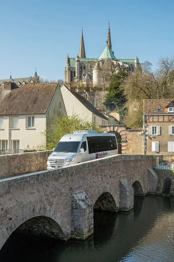 Back-Roads Touring enhances 2026 Wayfinders agency program + Sell 12 & win a fam trip 2 Back-Roads Touring mini-coach crossing a medieval bridge in the UK