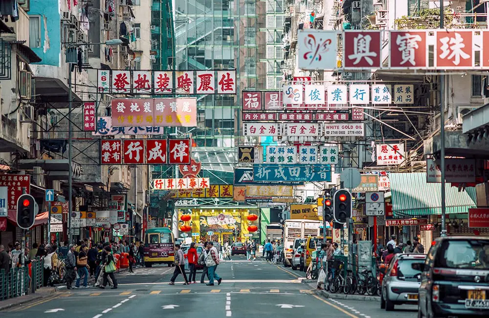 Busy city street scene with pedestrians and cars at Sham Shui Po in Hong Kong. Image: @factoryxii/HKTB
