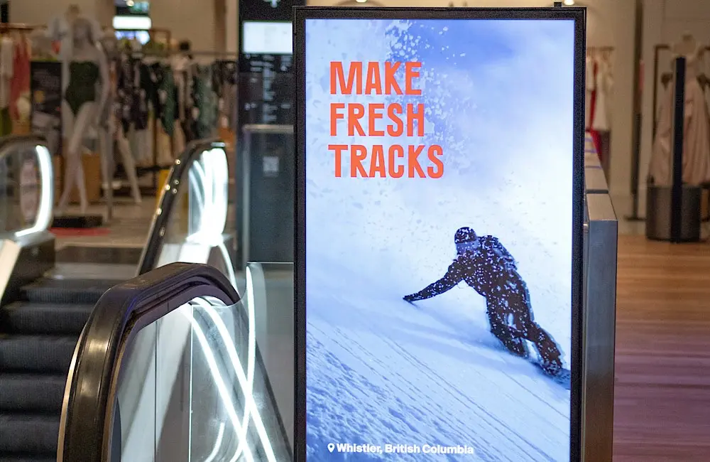 Canada drops its winter message into the daily commute inside David Jones, turning an escalator ride into a nudge towards fresh tracks in Whistler.