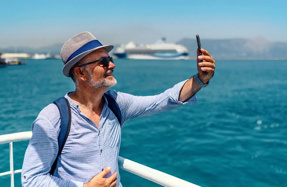 Who are 'granfluencers' and what do advisors need to know about their influence on travel? 1 Older male tourist takes a selfie on a ferry – granfluencers trend Image: bluecinema/iStock