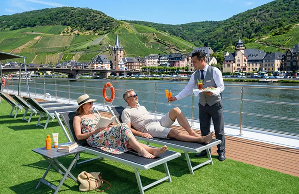 Couple being served drinks on Scenic Space Ship Sun Deck in Germany.