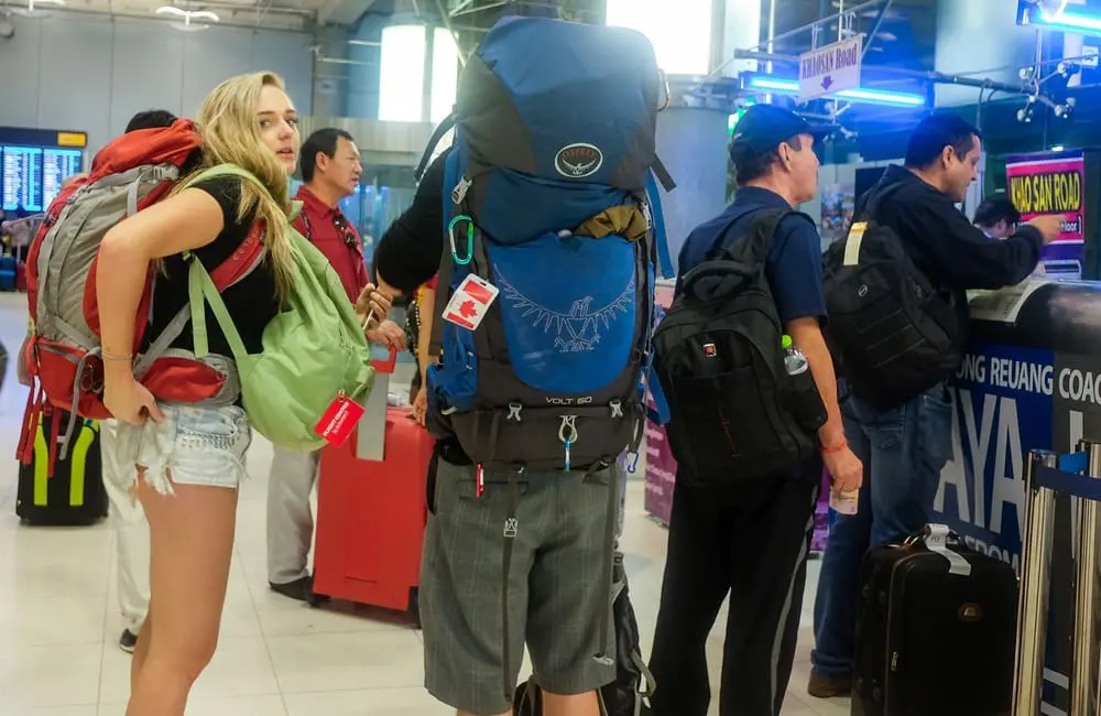 Travel safety concerns shape Australian holiday choices in 2026 as anxiety overtakes excitement 1 Female backpacker looks at camera while others queue to check-in at Bangkok Airport. Image: Zakk Bezz, Shutterstock