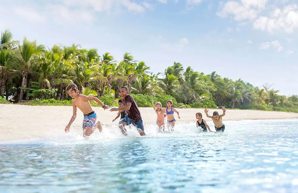 Kids running on the beach in Fiji. Image: Tourism Fiji