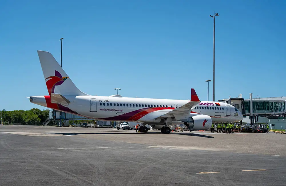 Air Niugini A220-300 aircraft at gate at Cairns Airport. Image: Bang Media