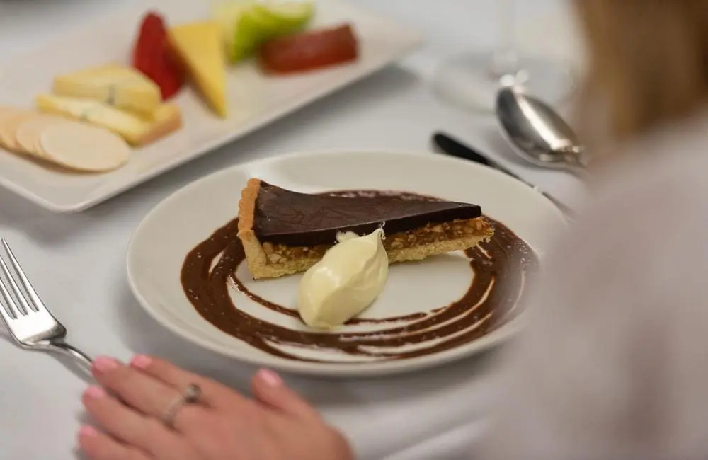 Close-up of dessert with female passenger on The Ghan rail journey.