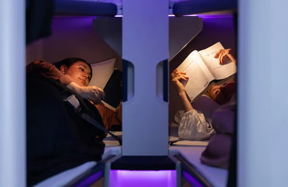 4-hour nap for $495: Air New Zealand’s innovative Economy Skynest sleep pods on sale from 18 May 1 Passengers reading in Air New Zealand Economy Skynest sleep pods