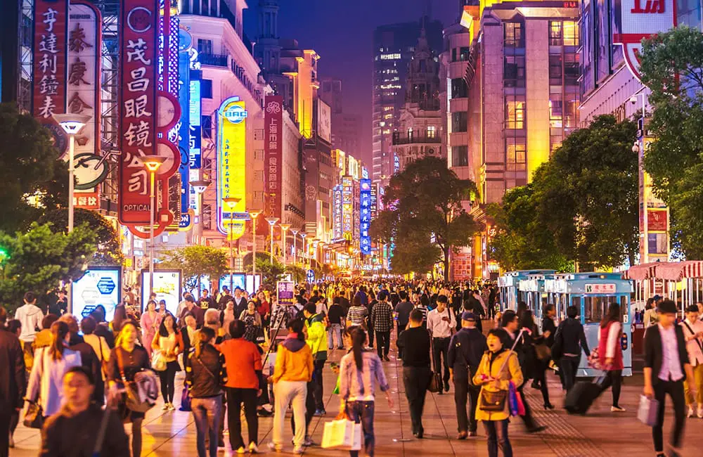 Busy Nanjing Road shopping street at night in Shanghai, China. Image: Nikada/iStock