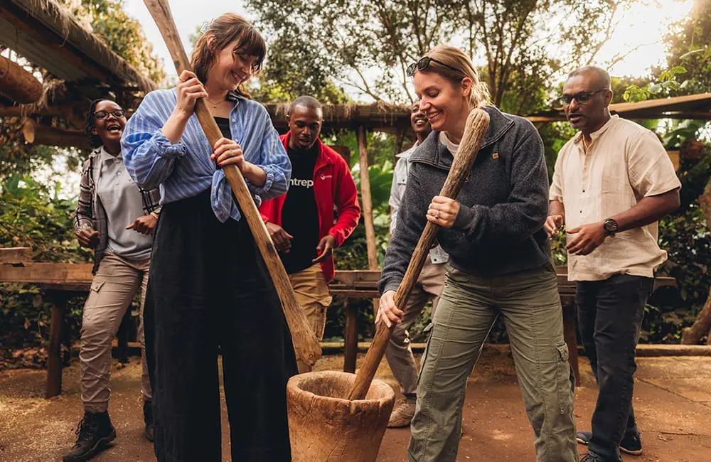 Intrepid Travel group mushing coffee beans at Karatu Organic Coffee Farm in Tanzania. Image: Intrepid Travel
