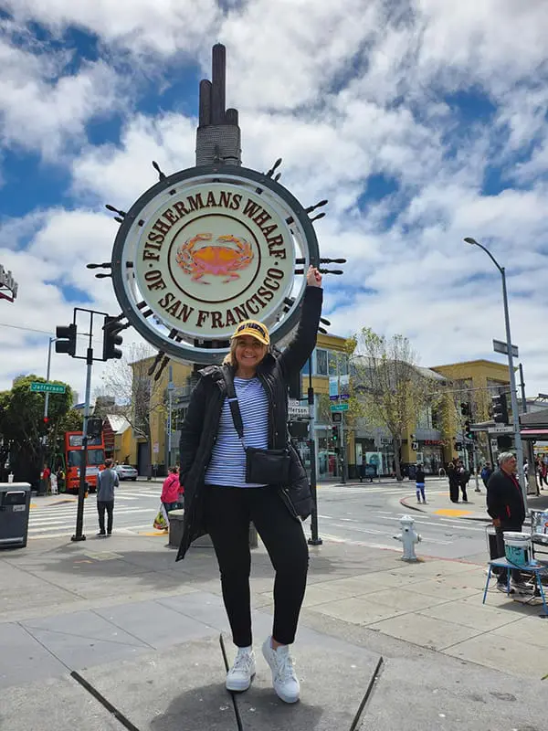 Windstar Cruises Sales Manager Australia Karli Donaldson with Fishermans Wharf sign in San Francisco.