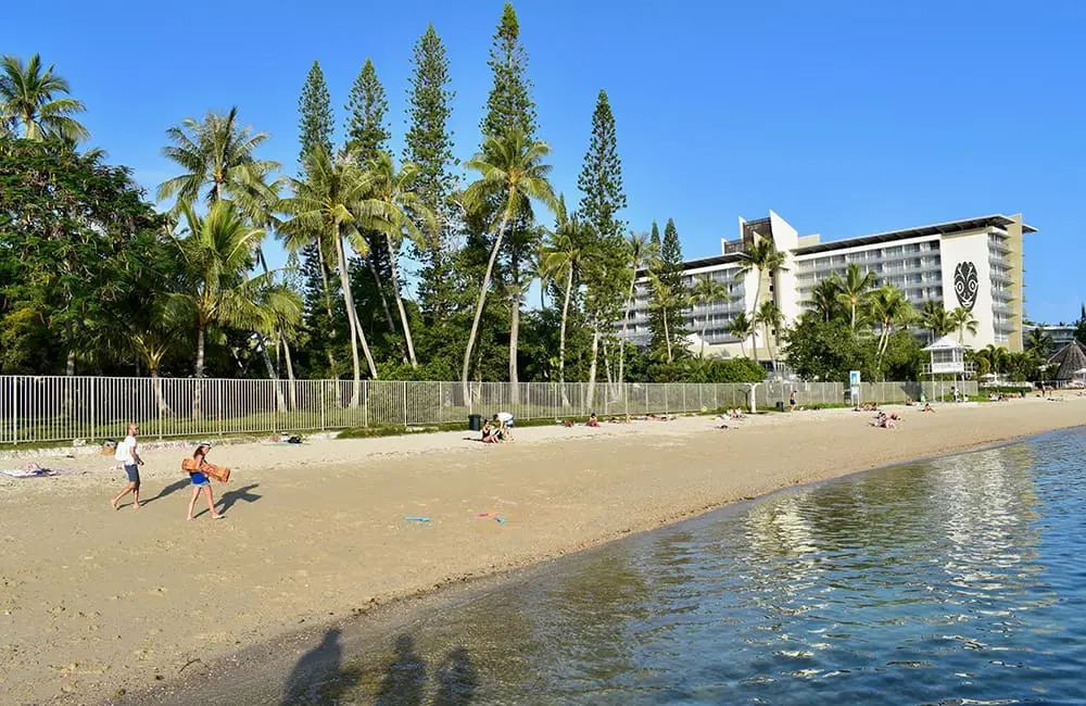 Strolling along Noumea's Plage du Chateau Royal on a city break. Image: NCT