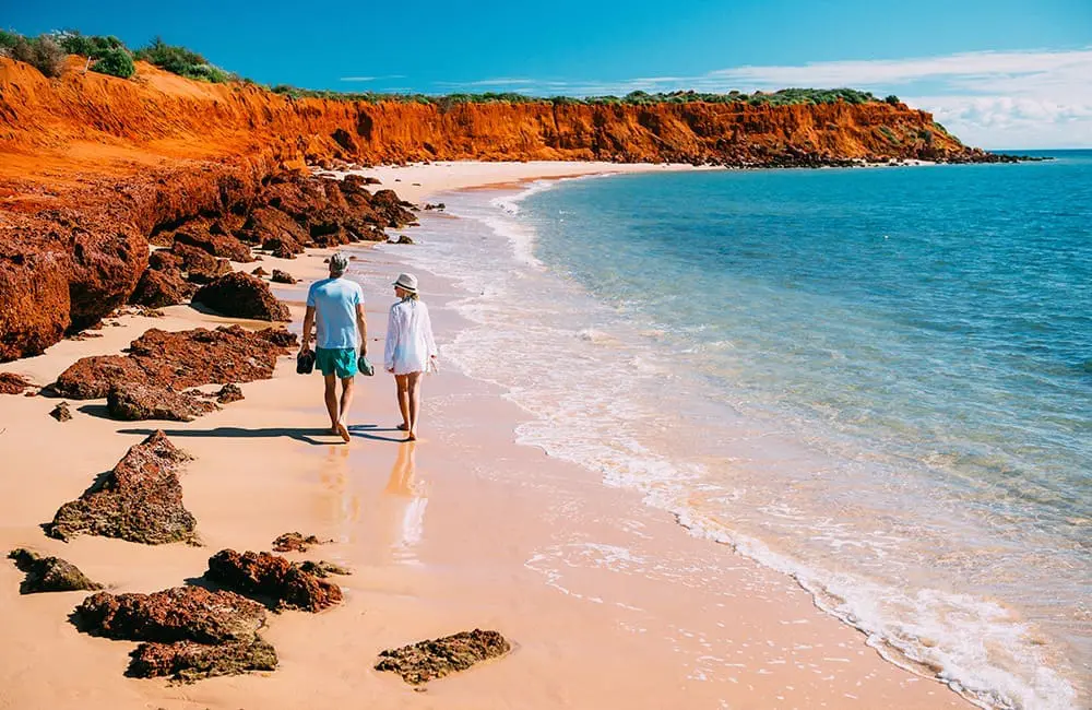 Couple walking along Francois Peron Beach on WA's Coral Coast. Image: Tourism WA