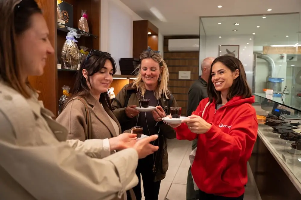 Intrepid launches Uncommon Day Trips in Barcelona, Paris and Venice amid overtourism concerns 2 Urban-Adventures-Italy-Venice-inside-chocolate-shop-Vizio-e-Virtu-leader-handing-out-food.jpg