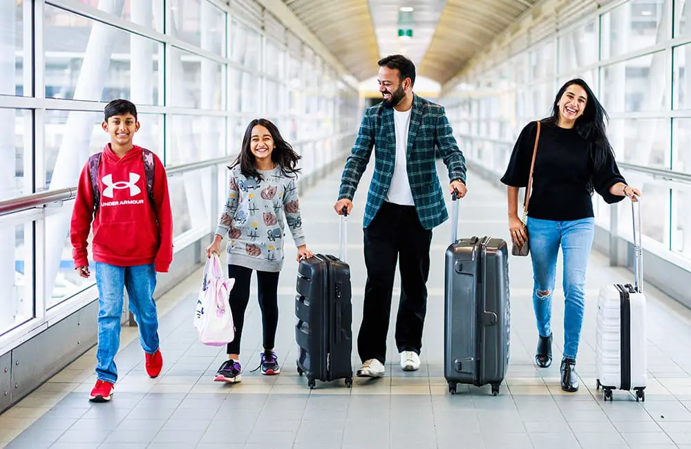 Family of 4 with suitcases at Melbourne Airport. Image: Melbourne Airport