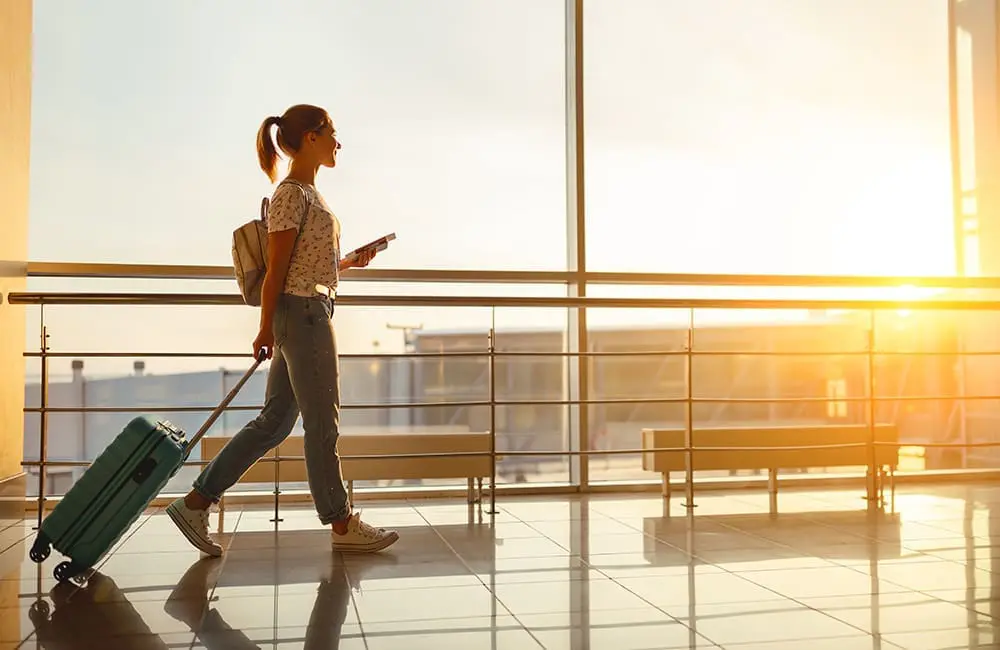 Female traveller walking through airport – Brand USA