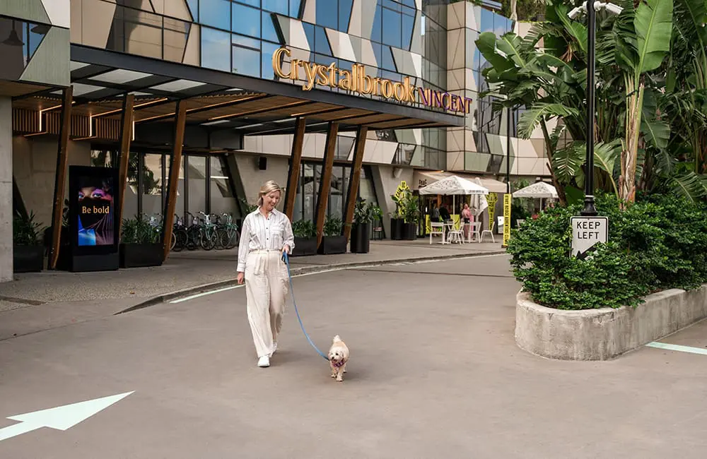 Woman walking her dog outside Crystalbrook Vincent hotel in Brisbane