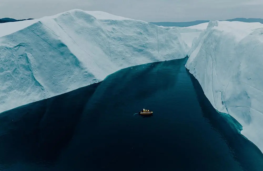 Aerial image of ship in Ilulissat, Greenland, surrounded by the  Ilulissat Icefjord.