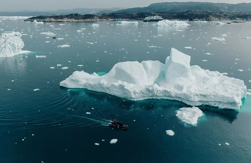 Aerial image of Zodiac boat amid ice on HX expedition aboard MS Fridtof Nansen in Ilulissat, Greenland.