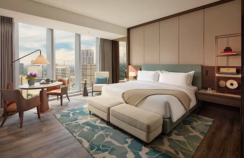 Deluxe Room King at Mandarin Oriental Makati, Manila, with floor-to-ceiling city views and contemporary residential-style interiors.