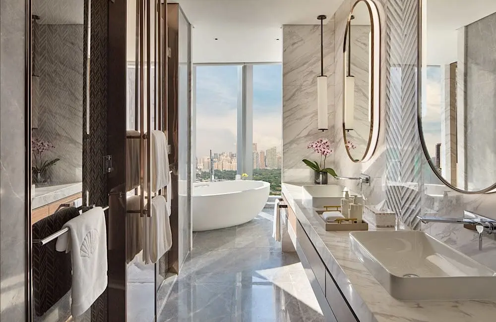 A Junior Suite bathroom at Mandarin Oriental Makati, Manila, where marble finishes and city views add to the sense of calm.