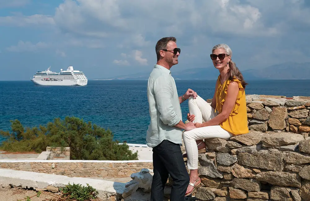 Wake up somewhere extraordinary: Oceania Cruises launches new collection with 50% reduced deposits 1 Couple in Greece with Oceania Cruises ship at sea in background