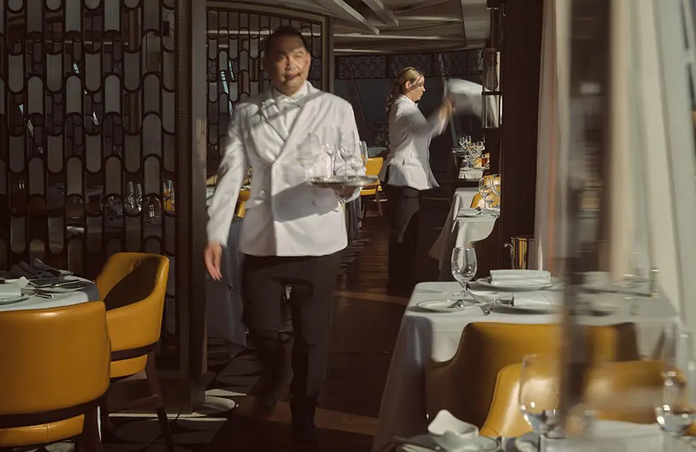 Wake up somewhere extraordinary: Oceania Cruises launches new collection with 50% reduced deposits 3 Waiters in restaurant aboard Oceania Allura cruise ship.