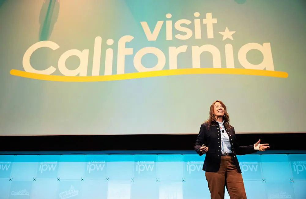 Outgoing Visit California President & CEO Caroline Beteta on stage at IPW 2026 in Fort Lauderdale. Image: Max Whittaker