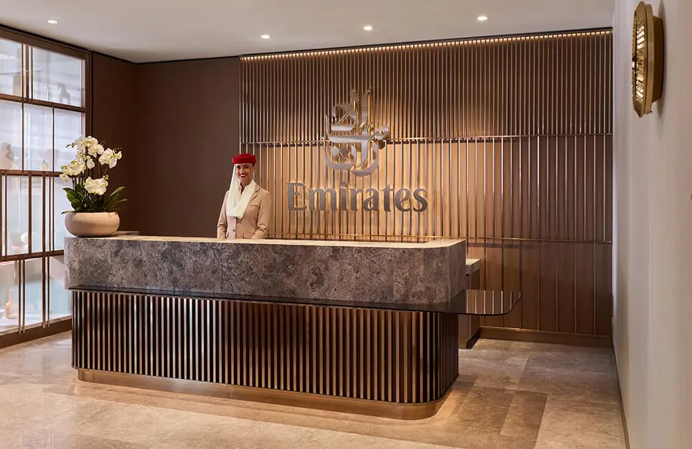 Emirates unveils next-gen lounge concept with Aussie cities on the global network rollout 1 Reception desk at Emirates Lounge in Munich with crew member. Image: Toby Mitchell