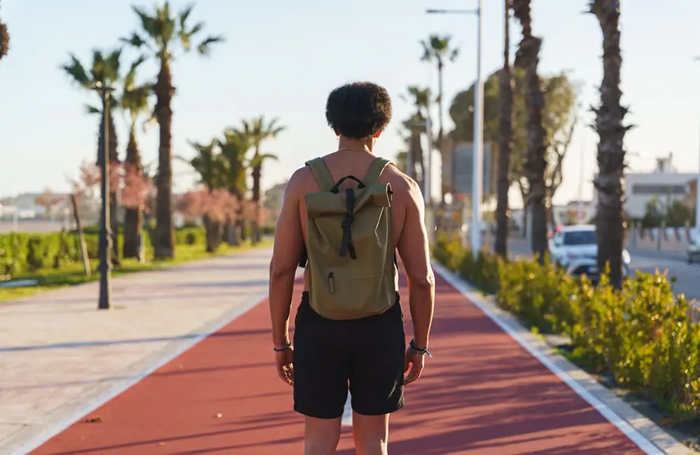 Bare-chested male backpacker with back to camera in Europe. Image: Pablo Leal Dominguez/iStock