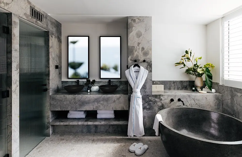 The marble-lined bathroom inside one of Elysium Manly’s refurbished suites.