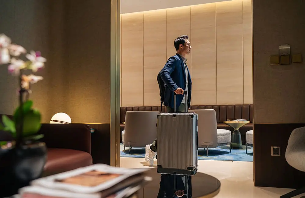 Male passenger wheeling luggage in airport lounge. Image: Sze kiat Koh/iStock