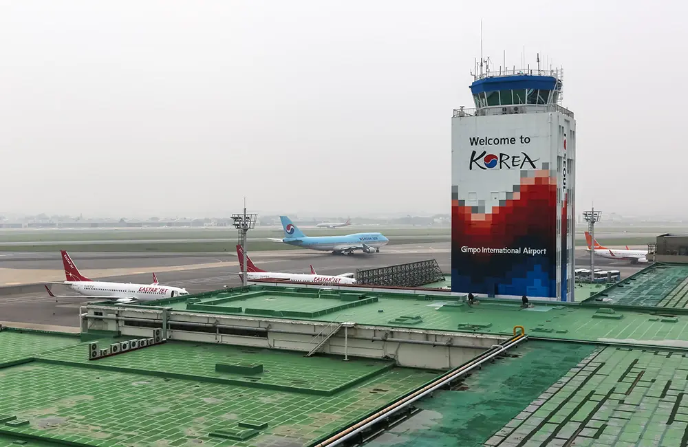 First class and business booms: What IATA's 2025 aviation data means for Australia 3 Airport tower with planes at Seoul Gimpo International Airport.