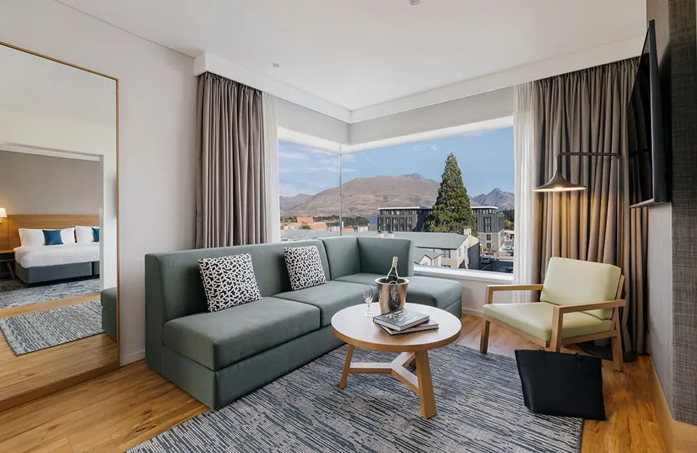 One King Bedroom Suite living room with a mountain view at voco Queenstown. Image: IHG Hotels & Resorts